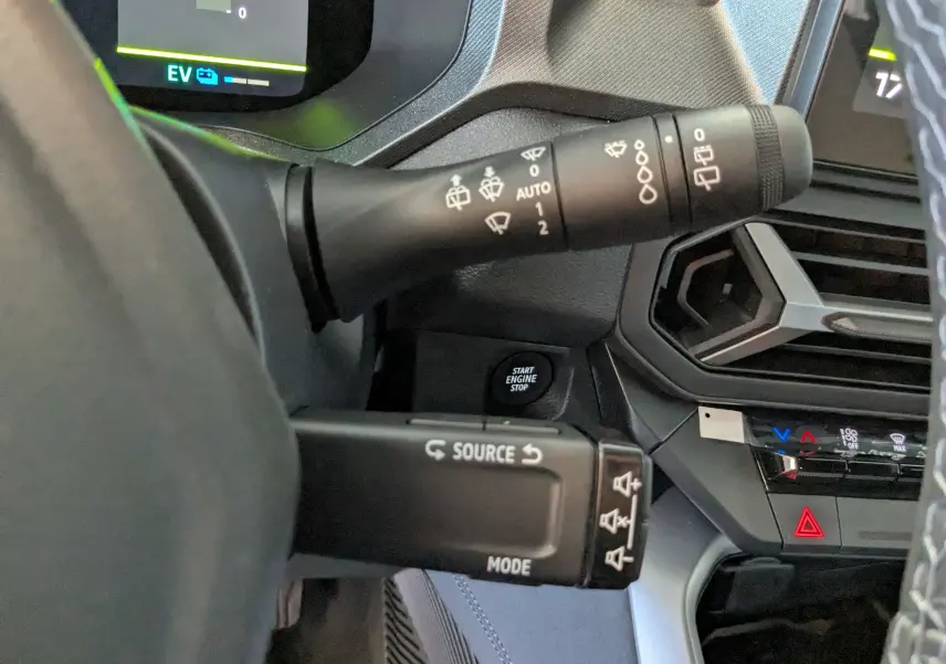 Gros plan sur les commandes au volant et le bouton start/stop du tableau de bord du Dacia Bigster Hybrid 155 Journey.