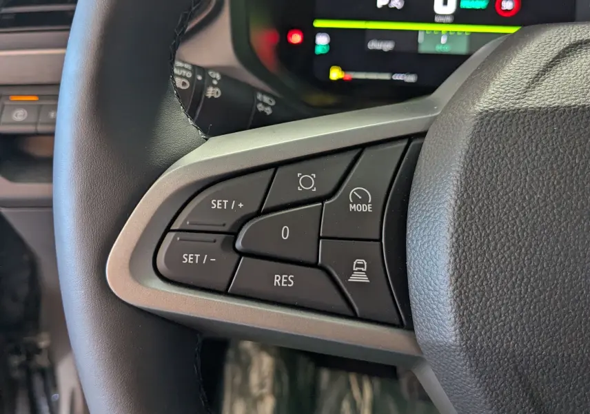 Gros plan sur les commandes au volant à gauche du Dacia Bigster Hybrid 155 Journey 2026, avec boutons de régulateur et mode.