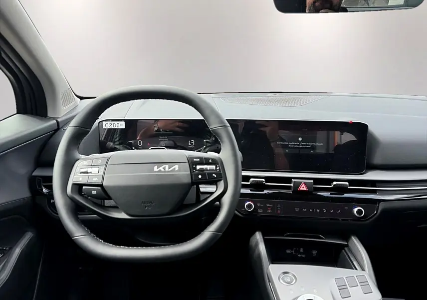 Vue intérieure frontale du tableau de bord et volant cuir noir du Kia Sportage 1.6 hybride gris eclipse 2026.