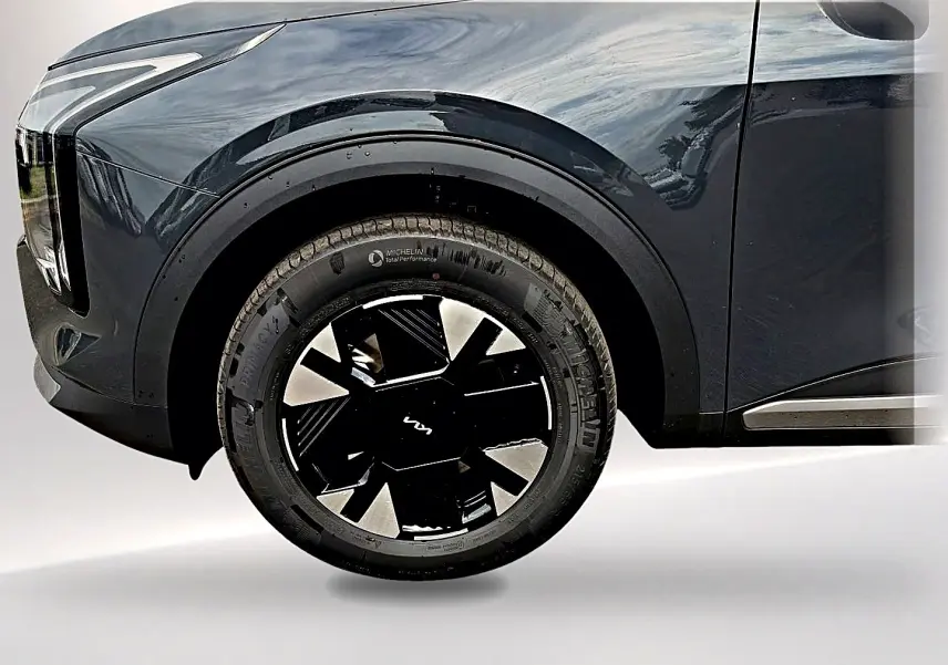 Gros plan sur la roue avant gauche du KIA SPORTAGE gris eclipse avec jante alu noire et détails modernes.