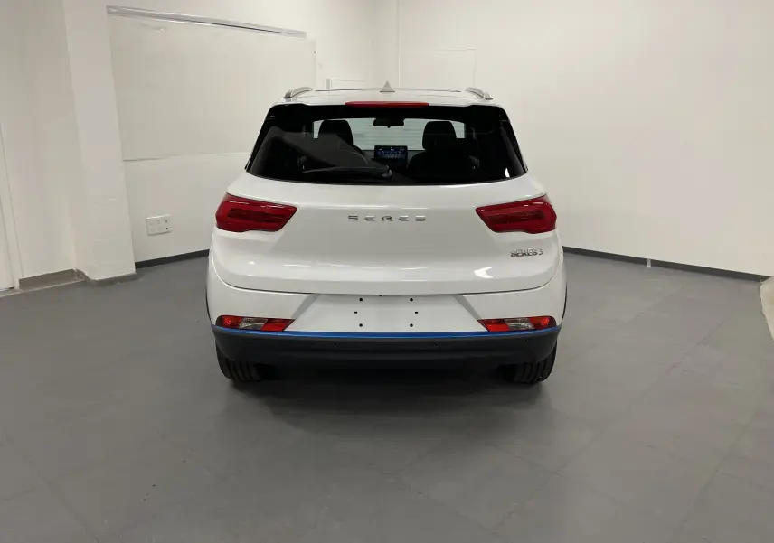 Vue arrière du SUV électrique blanc SERES 3 Luxury, avec feux rouges et vitres arrière teintées dans un garage.