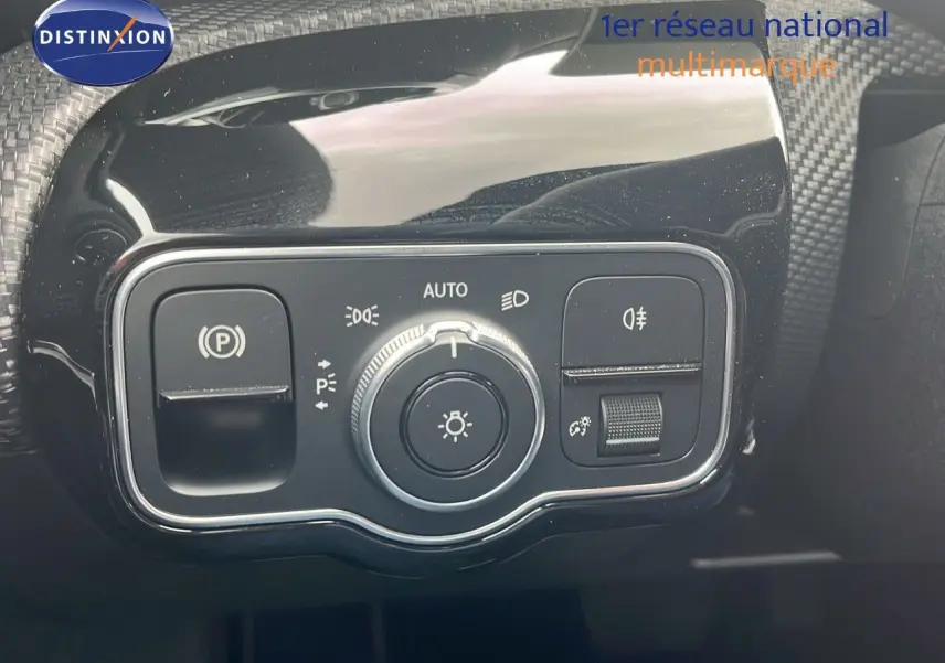 Gros plan sur le panneau de commande des phares et du frein à main électrique d'une Mercedes CLA Shooting Brake argent iridium.