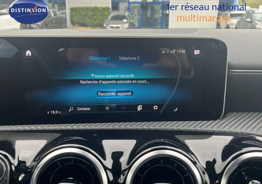 Tableau de bord intérieur d'une Mercedes Classe CLA Shooting Brake 180 argent, avec écran tactile et aérateurs ronds noirs.