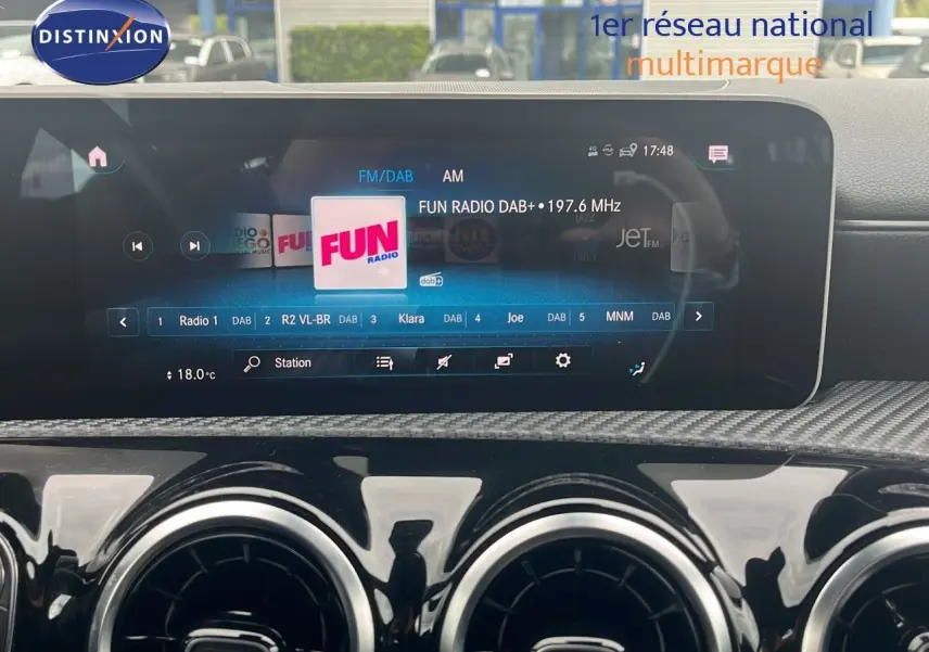 Écran multimédia et tableau de bord noir brillant d'une Mercedes Classe CLA Shooting Brake 180 argent iridium, affichant la radio Fun.