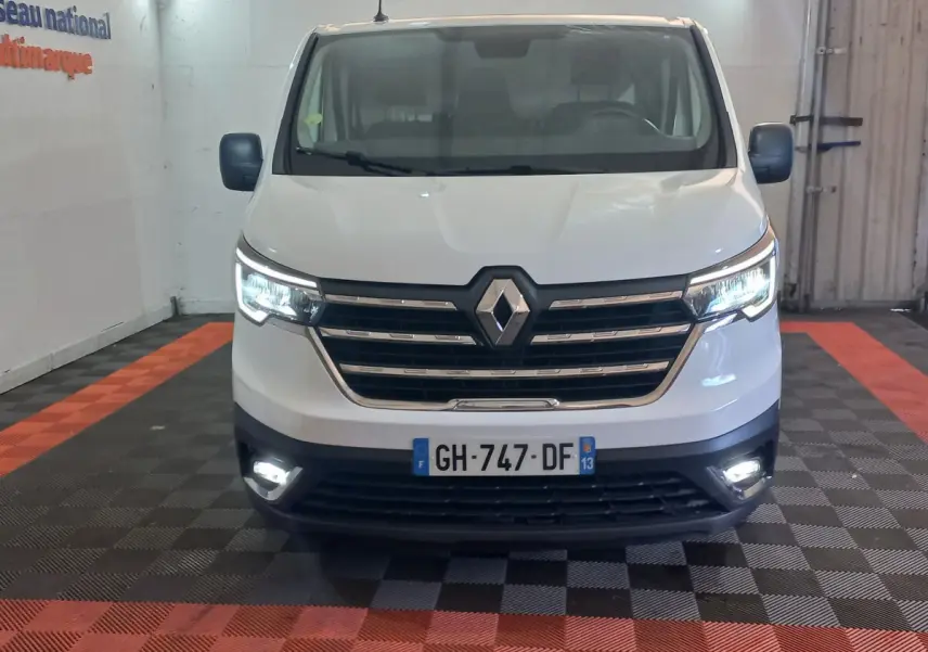 Vue frontale d’un Renault Trafic Fourgon blanc 2022 avec phares LED allumés dans un garage.