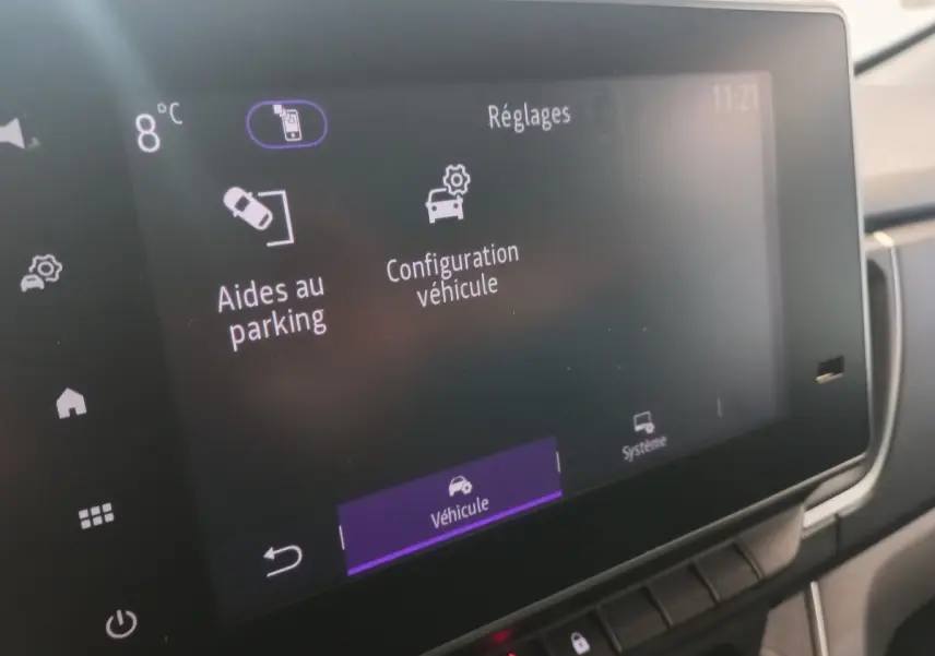 Écran tactile central du Renault Trafic Fourgon blanc, affichant les réglages d'aides au parking et configuration véhicule.