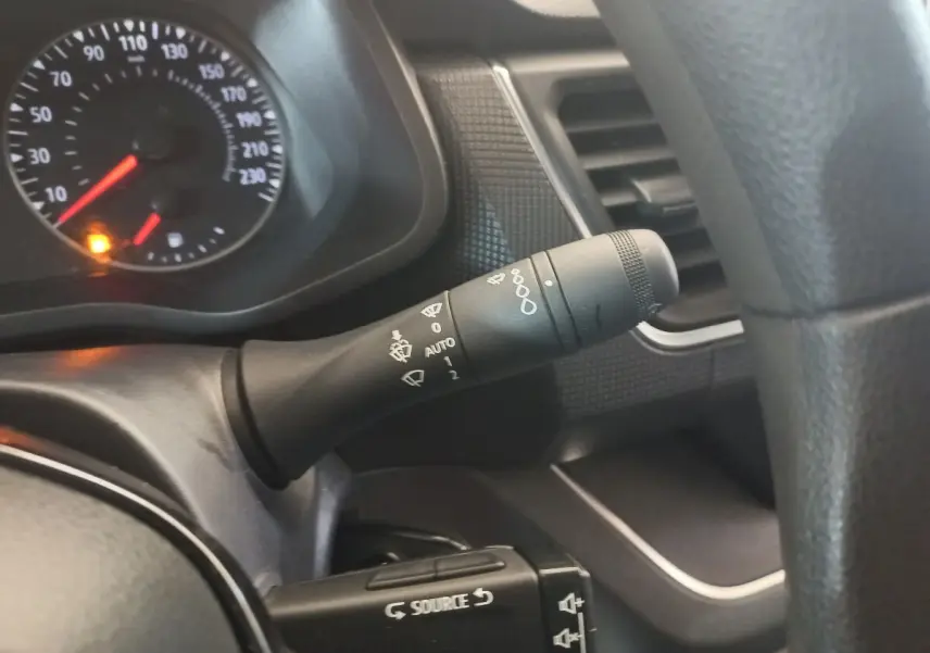 Gros plan sur la commande d’essuie-glace et le tableau de bord noir du Renault Trafic Fourgon blanc, vue côté conducteur.