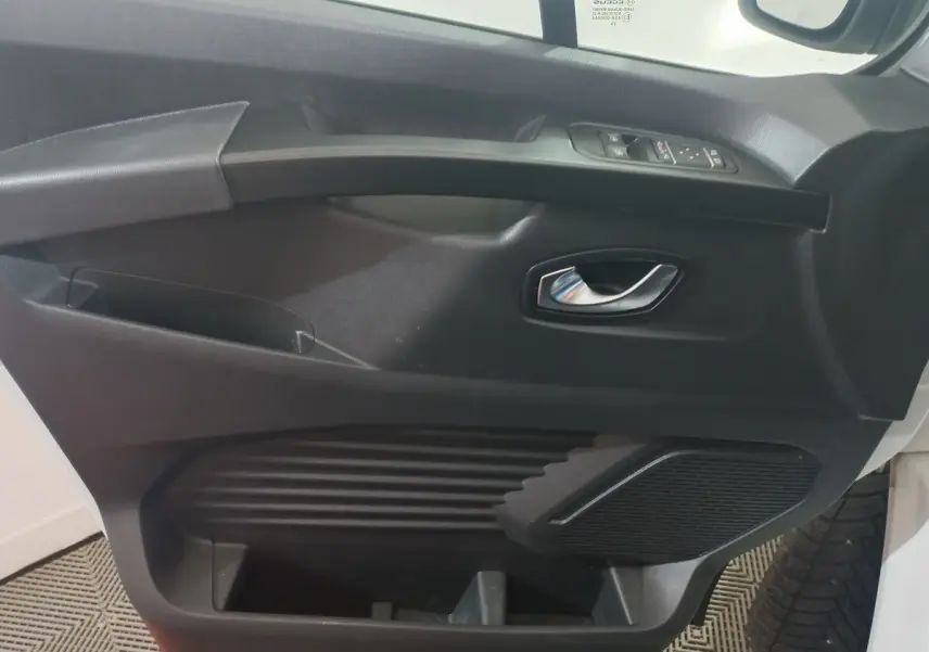 Vue rapprochée de la porte avant droite noire du Renault Trafic Fourgon avec poignée argentée et commandes électriques.