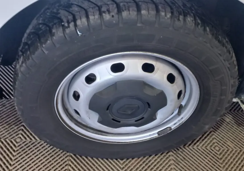 Gros plan sur la roue avant droite blanche du Renault Trafic Fourgon avec jante acier et logo Renault central.