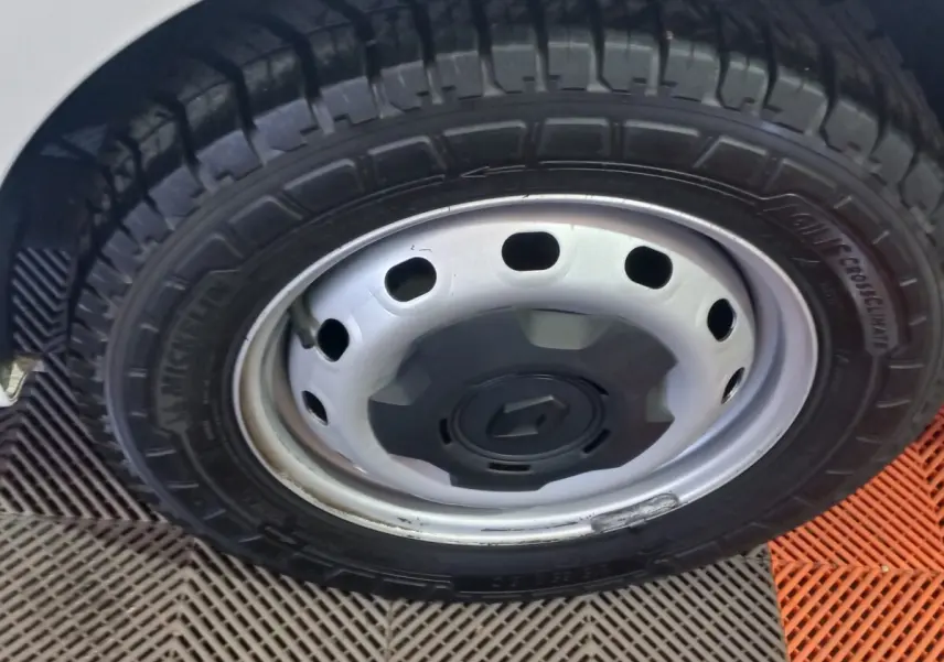 Gros plan sur la roue avant gauche du Renault Trafic Fourgon blanc, jante acier avec logo Renault central.