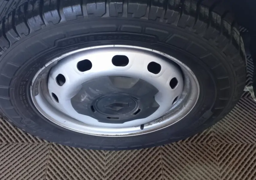 Gros plan sur la roue avant droite du Renault Trafic Fourgon blanc, avec jante acier et logo Renault central.