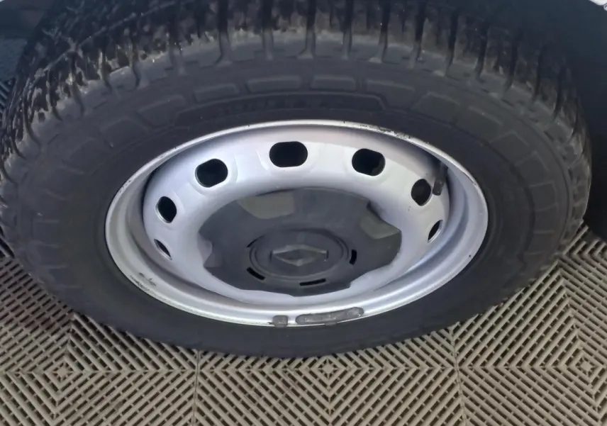 Gros plan sur la roue avant droite blanche du Renault Trafic Fourgon avec jante acier et logo central noir.