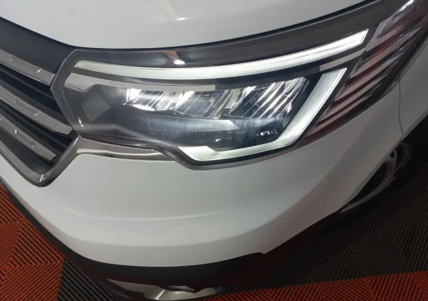 Gros plan sur le phare avant droit blanc du Renault Trafic Fourgon 2022 avec calandre chromée et éclairage LED.