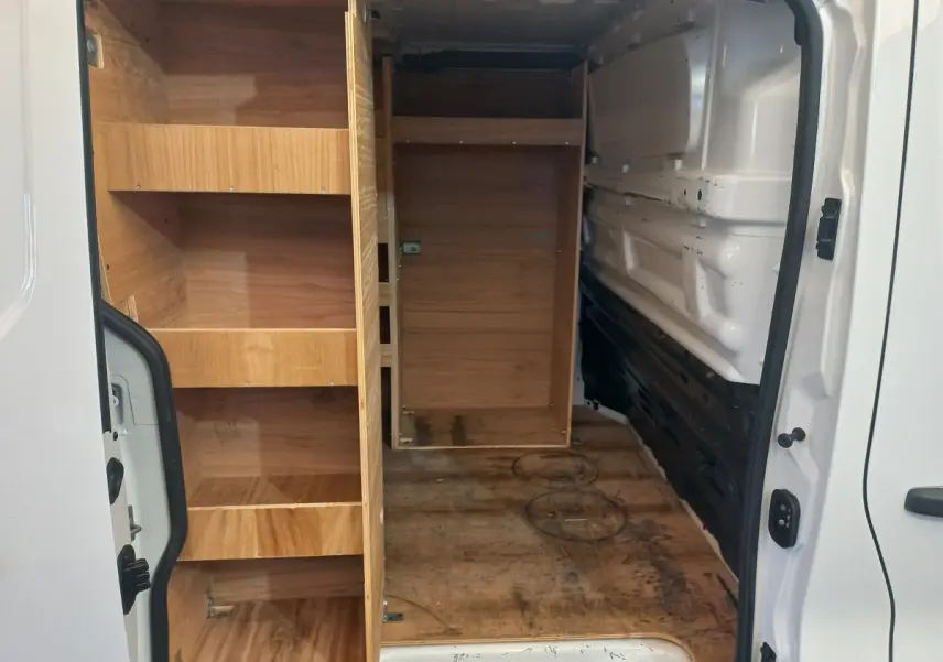Vue intérieure arrière droite du Renault Trafic Fourgon blanc 2022 avec aménagements en bois et espace de chargement visible.