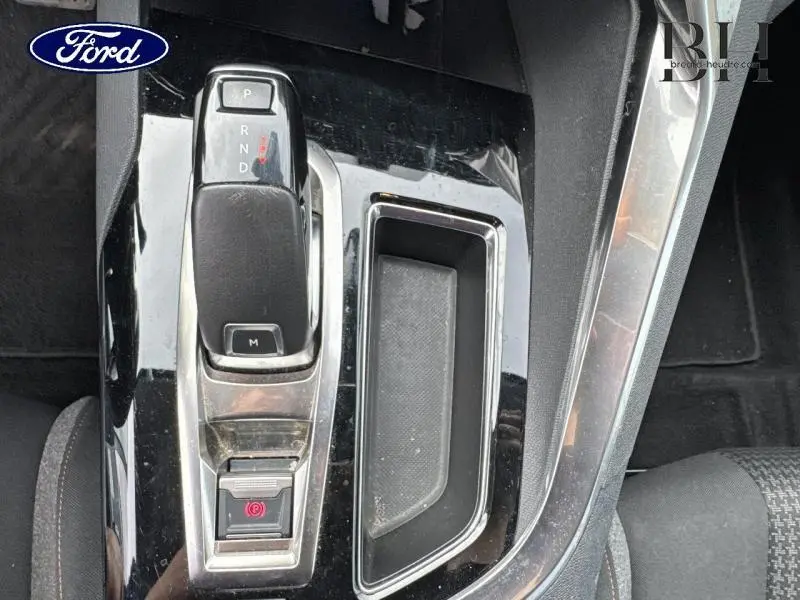 Le levier de vitesse automatique et le frein à main électronique sur la console centrale noire brillante d’un Ford.