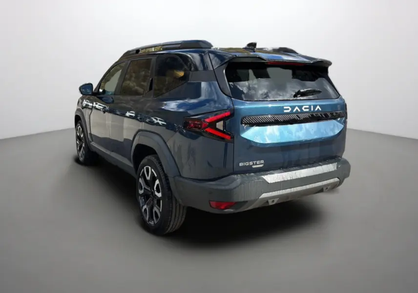 Vue 3/4 arrière droite du Dacia Bigster bleu indigo avec toit noir et jantes alu 19 pouces sur fond neutre.