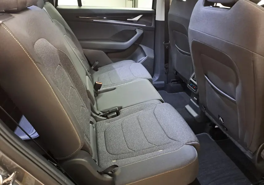 Vue intérieure des sièges arrière en tissu gris avec surpiqûres contrastantes du Skoda Kodiaq 2025, côté droit.