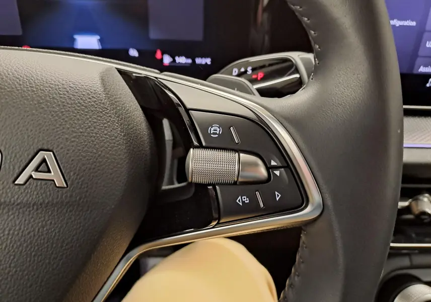 Gros plan sur les commandes multifonctions à droite du volant cuir du Skoda Kodiaq gris graphite 2025, avec levier de vitesses digital visible.