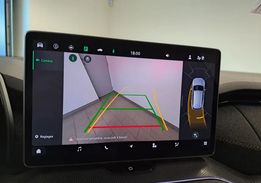 Écran tactile intérieur montrant la caméra de recul et l’aide au stationnement du Skoda Kodiaq gris graphite, vue de face.