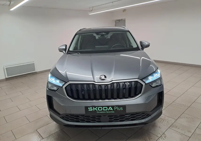 Vue frontale d'un Skoda Kodiaq 2025 gris graphite avec phares LED allumés et calandre noire distinctive.
