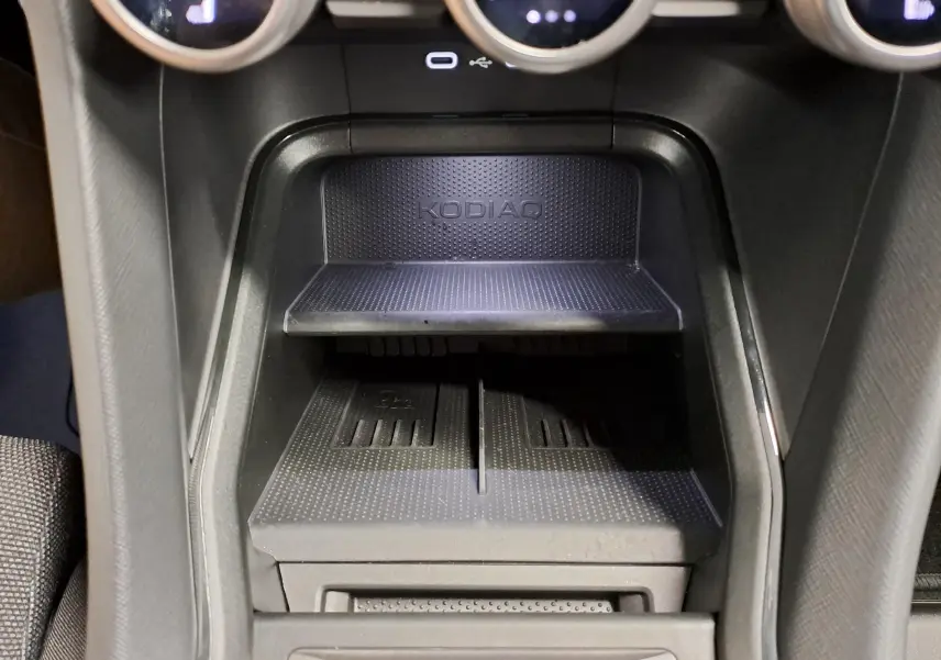 Gros plan sur la console centrale noire du Skoda Kodiaq 2025 avec espace de rangement marqué KODIAQ.