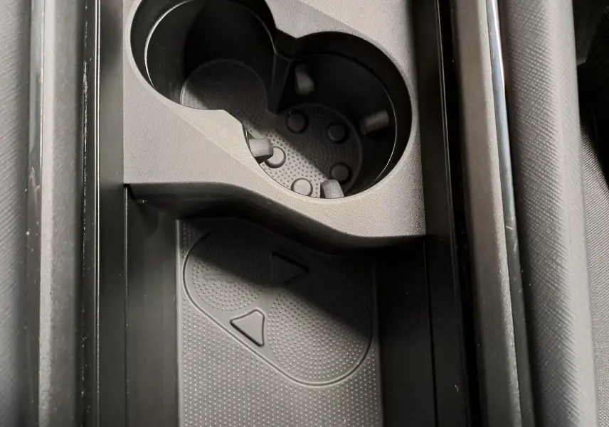Vue rapprochée de la console centrale noire du Skoda Kodiaq 2025, avec porte-gobelets et surface antidérapante.