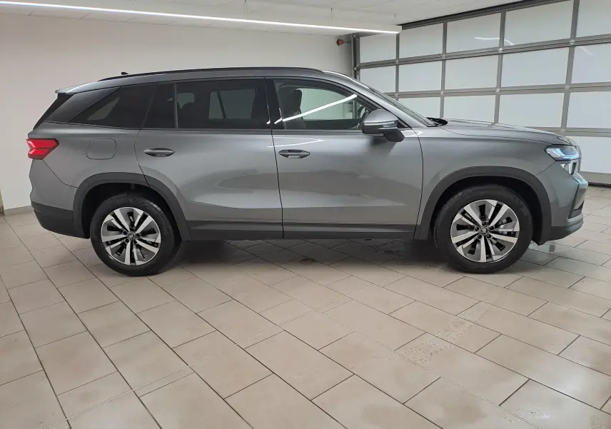 Vue de profil côté droit d'un Skoda Kodiaq 2025 gris graphite avec jantes alliage 18'' Soira anthracite et vitres surteintées.