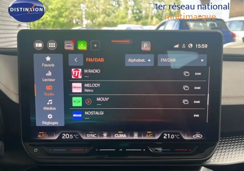 Écran tactile central du tableau de bord du CUPRA Formentor 1.5 eTSI bleu Fjord, affichant les radios FM/DAB.