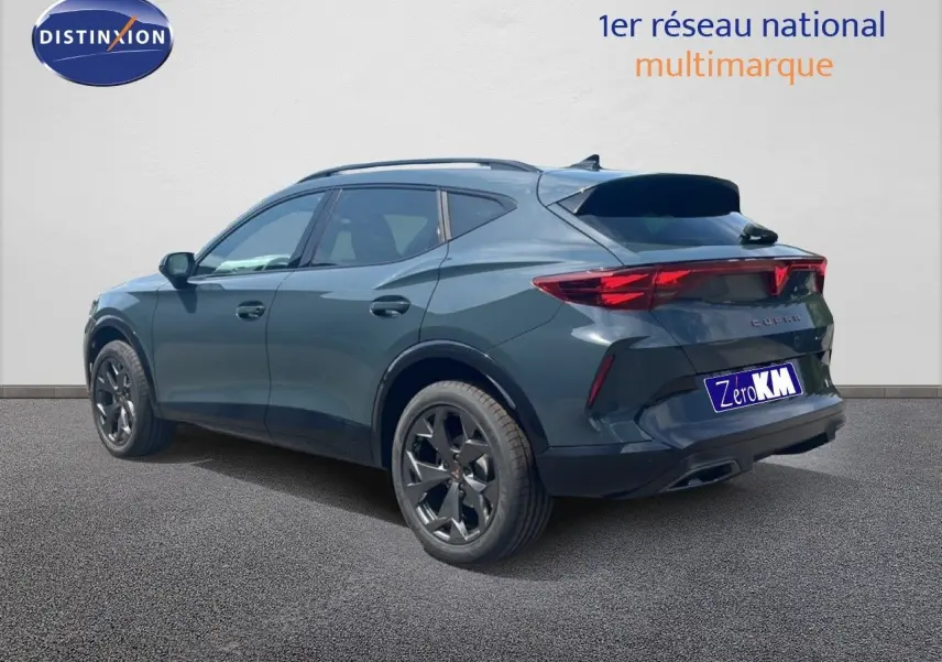 Vue 3/4 arrière droite d'un CUPRA Formentor bleu Fjord métal avec jantes noires et feux arrière allumés.