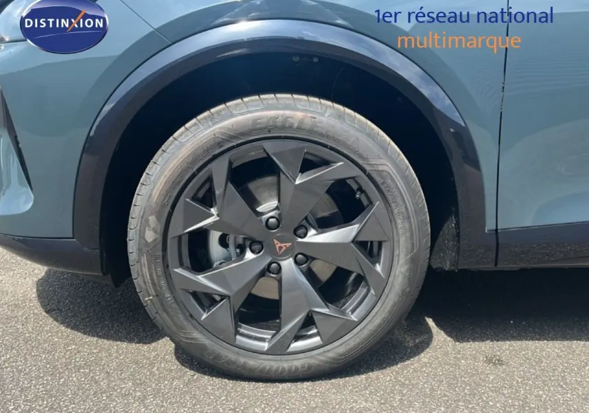 Gros plan sur la roue avant gauche du CUPRA Formentor bleu Fjord Métal avec jante noire au design anguleux.