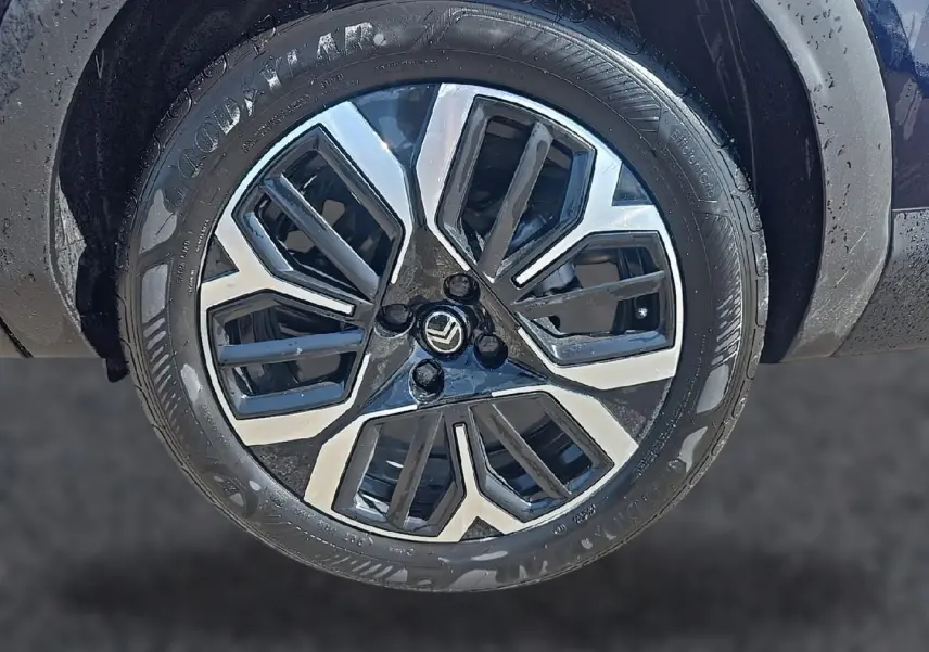 Gros plan sur la jante alu bicolore noire et argentée d’une Citroën C4 X bleu, avec pneu Goodyear visible.