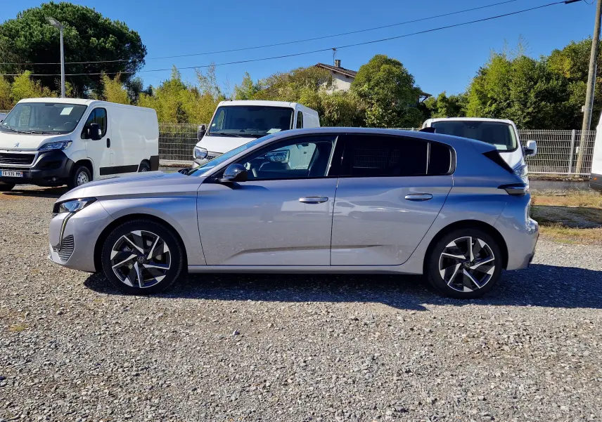 Peugeot 308 gris Artense vue de profil côté gauche, avec jantes alliage noires et toit foncé contrastant.