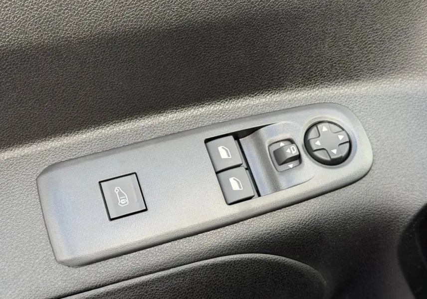 Gros plan sur les commandes de réglage des rétroviseurs et des vitres côté conducteur du Peugeot Partner blanc Icy 2026.