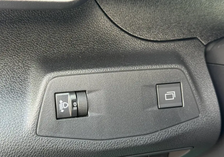 Gros plan sur les commandes d’éclairage et de réglage des rétroviseurs dans un Peugeot Partner blanc Icy 2026.