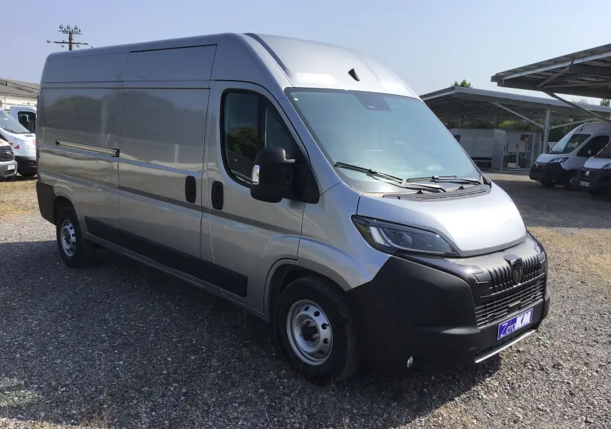 Fourgon Peugeot Boxer L3H2 gris Artense vu en 3/4 avant droit, avec calandre noire et projecteurs LED visibles.