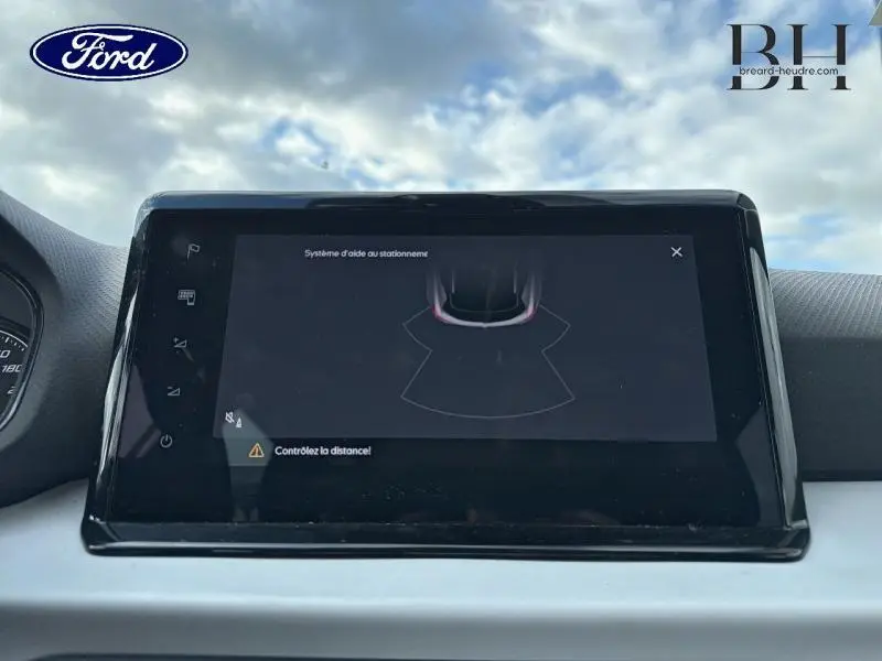 Écran tactile du système d'aide au stationnement arrière dans l'habitacle d'une SEAT Arona gris urbain métal.