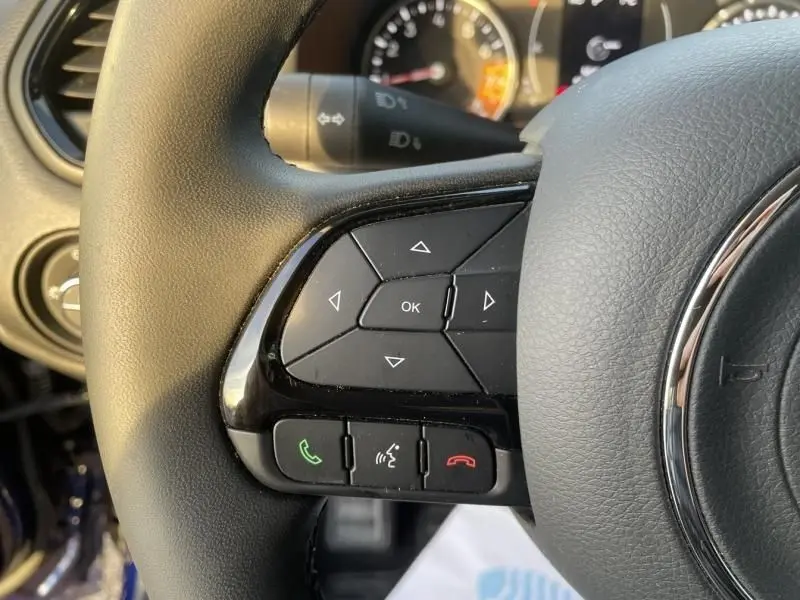 Gros plan sur les commandes au volant côté gauche du Jeep Renegade 2021, volant cuir noir avec boutons multifonctions.