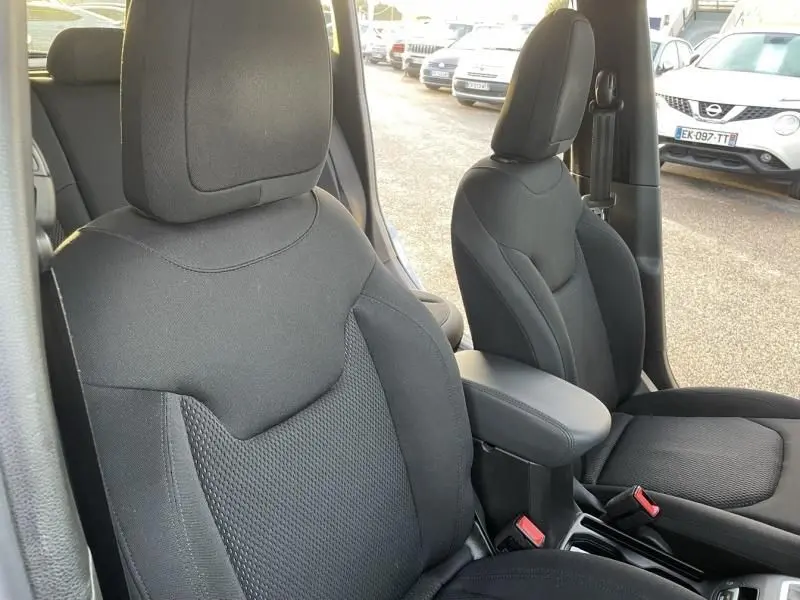 Vue rapprochée des sièges avant noirs en tissu du Jeep Renegade 2021, avec accoudoir central visible.