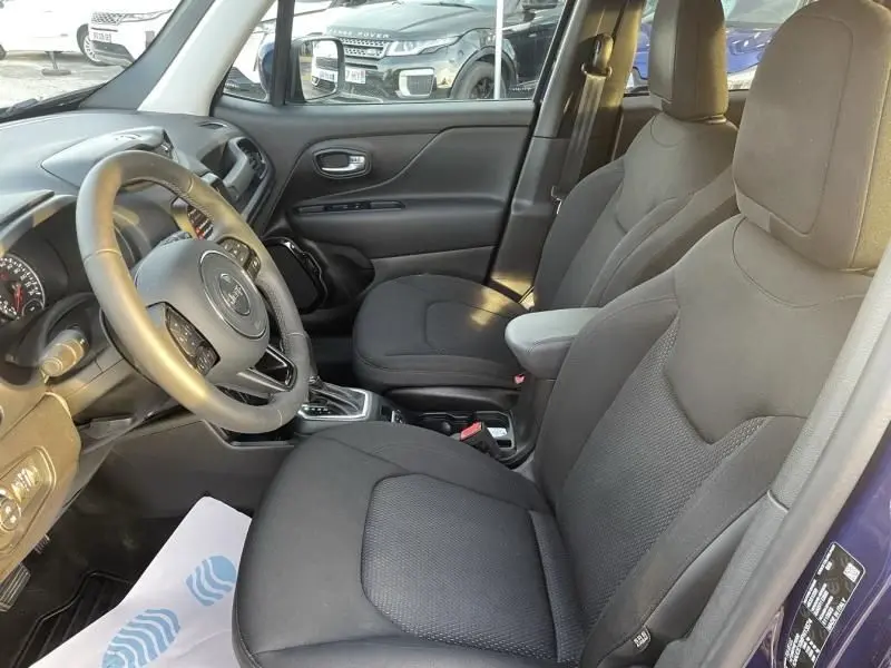 Vue intérieure côté conducteur du Jeep Renegade bleu Jetset Metal, sièges tissu noirs et volant cuir multifonction.