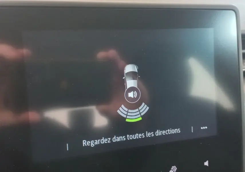 Écran tactile intérieur montrant l'alerte de capteurs de distance sur Renault Clio Business blanc, vue de dessus du véhicule.