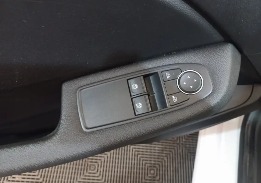 Gros plan sur les commandes des vitres et rétroviseurs côté conducteur de la Renault Clio Business blanche 2021.