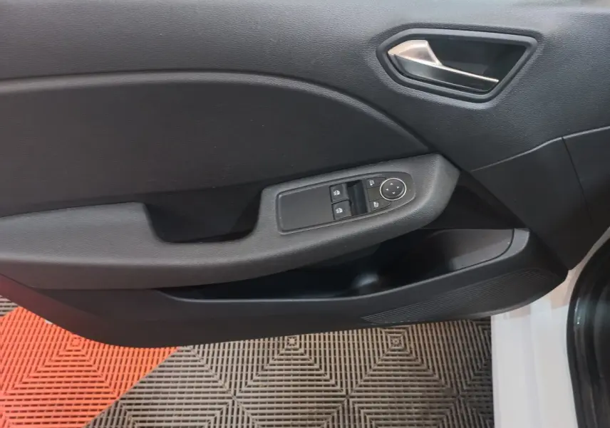 Vue rapprochée de la porte avant gauche noire de la Renault Clio Business blanche, avec commandes électriques et poignée argentée.