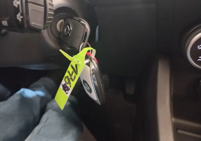 Vue intérieure du contacteur de clé Renault Clio Business 2021 avec porte-clés noir et blanc et étiquette jaune.