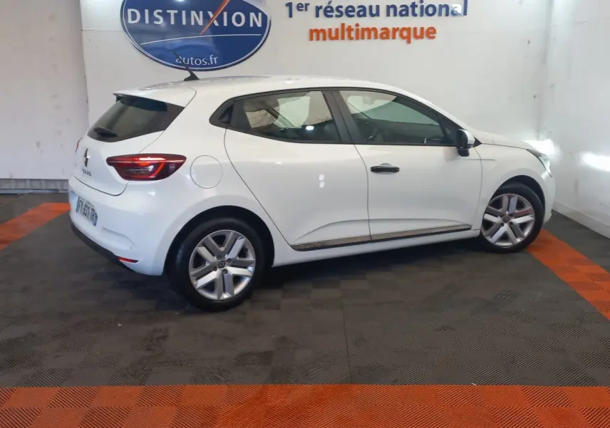 Renault Clio Business blanche vue de profil côté droit dans un showroom avec sol noir et bandes orange.