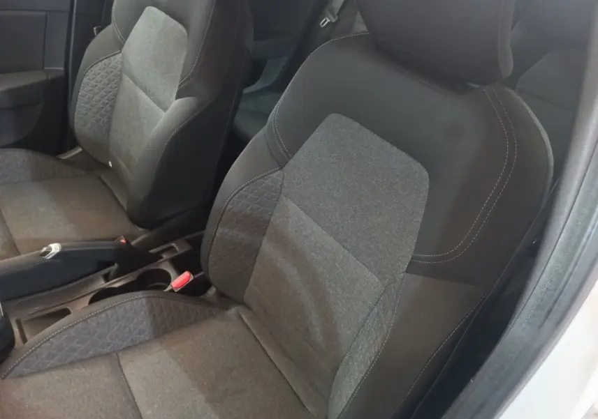 Vue rapprochée des sièges avant gris foncé et tissu de la Renault Clio Business SCe 65 blanche, intérieur sobre.