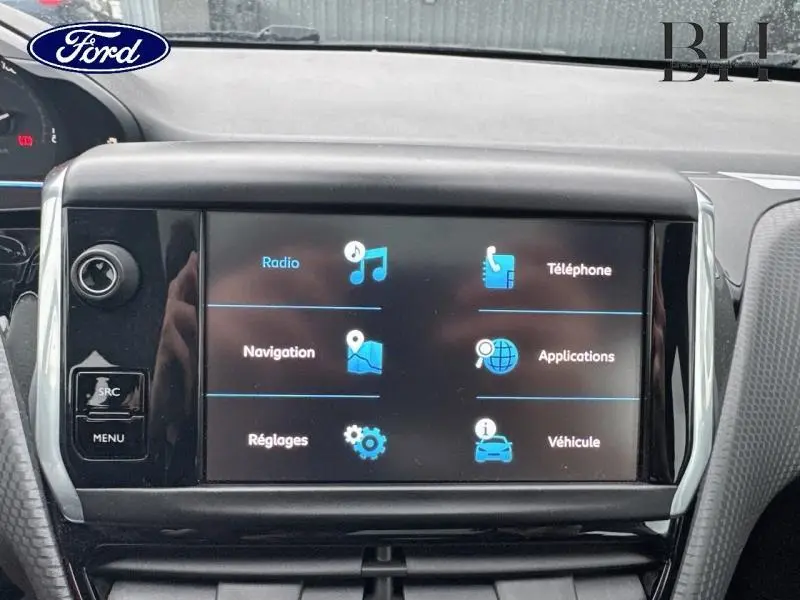 Vue rapprochée de l'écran tactile multimédia du Peugeot 2008 blanc, affichant les options radio, navigation et téléphone.