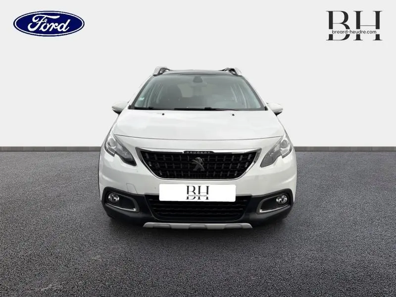 Vue avant d'un Peugeot 2008 blanc Banquise avec calandre noire et détails chromés sur fond neutre.