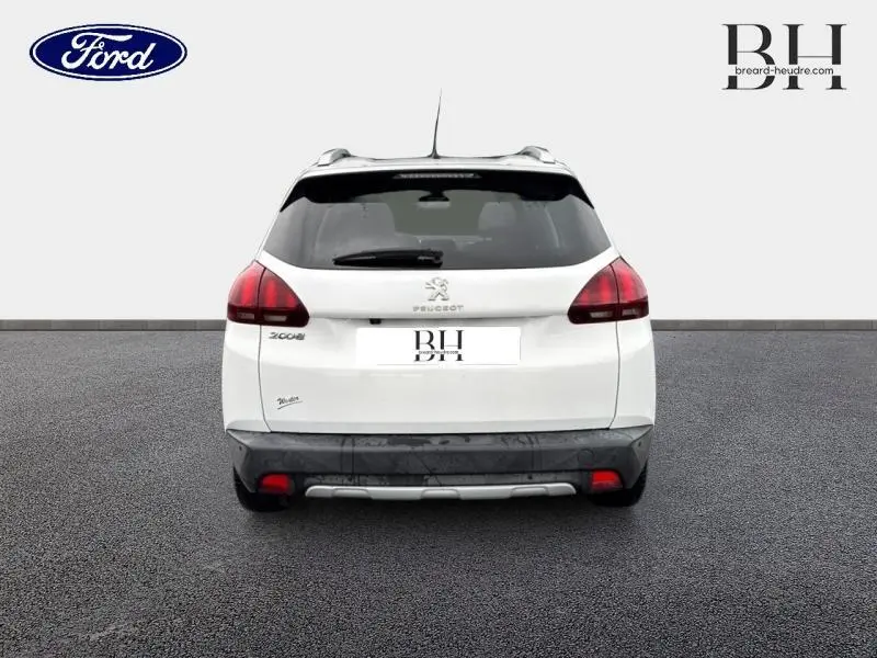 Vue arrière d’un Peugeot 2008 blanc Banquise avec feux arrière LED et barres de toit visibles.