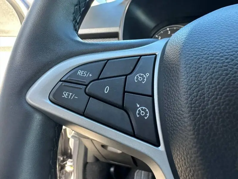 Gros plan sur les commandes de régulateur de vitesse au volant du Dacia Jogger 2025, intérieur noir.