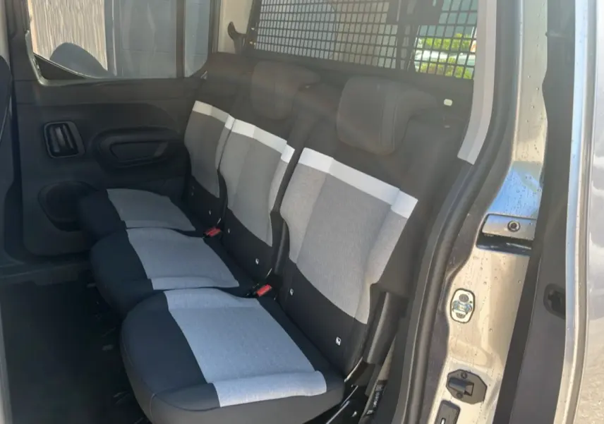 Vue latérale intérieure montrant les trois sièges arrière indépendants gris et noirs du Citroën Berlingo gris artense.